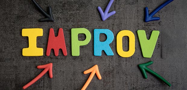 A dark background with arrows pointing the word IMPROV