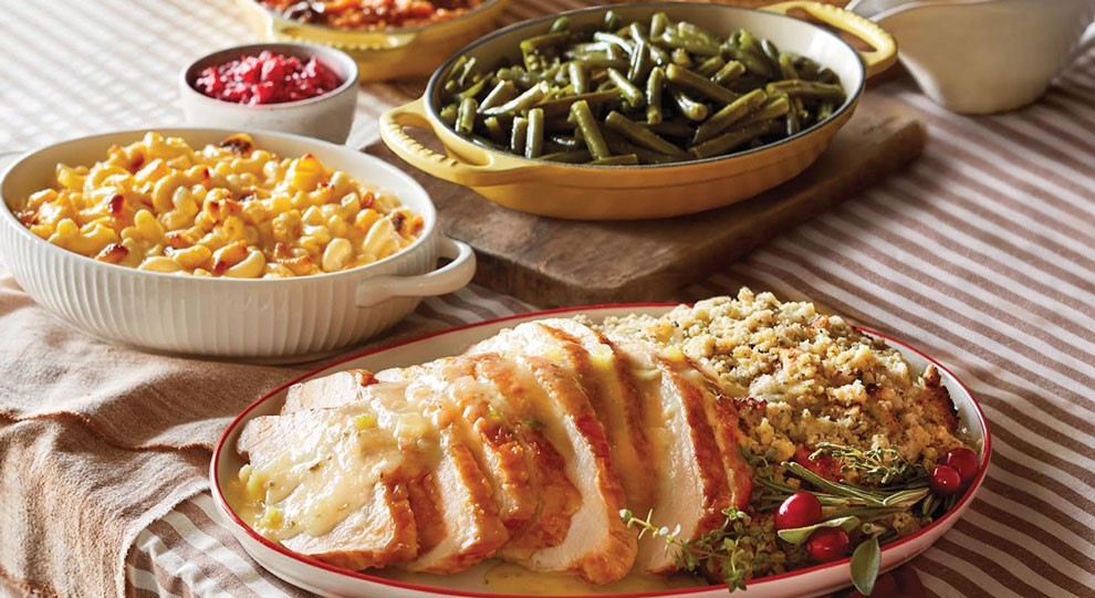 Family style meal including green beans macaroni and cheese pork loin and stuffing.