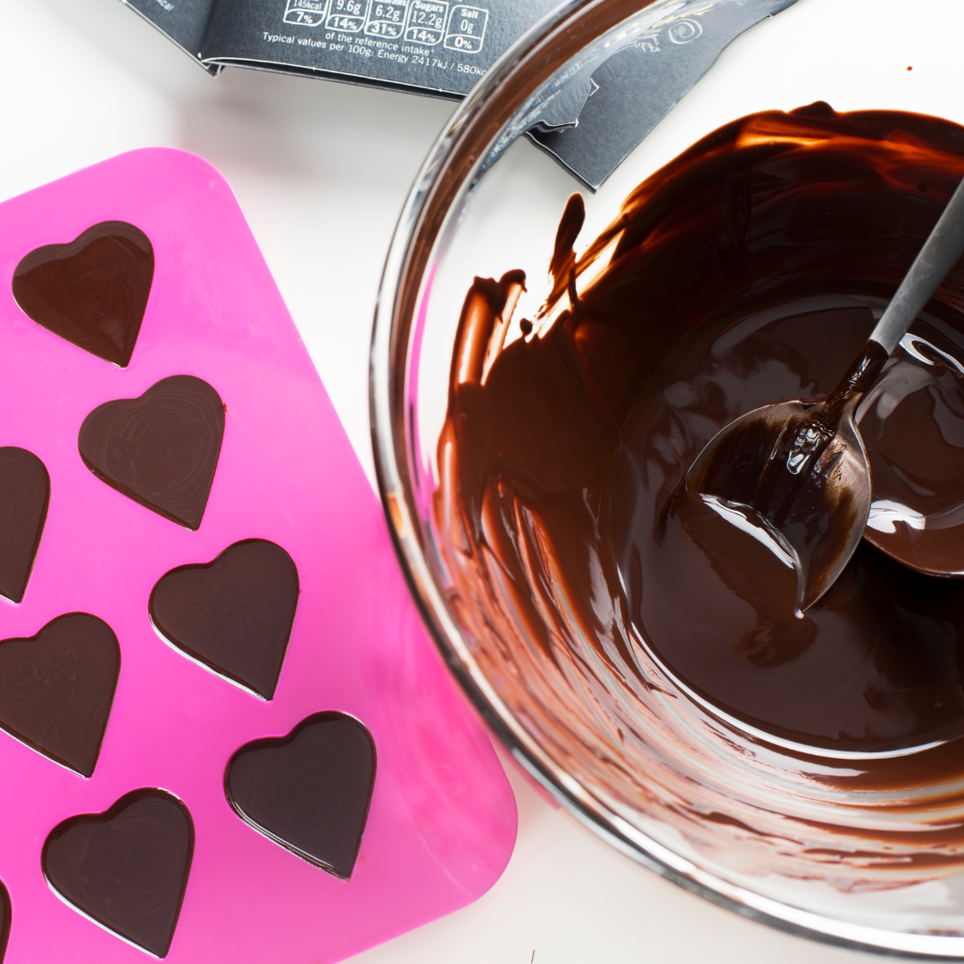 Heart-shaped chocolate mold and bowl of melted chocolate