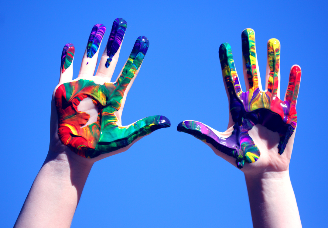 Two hands painted rainbow colors