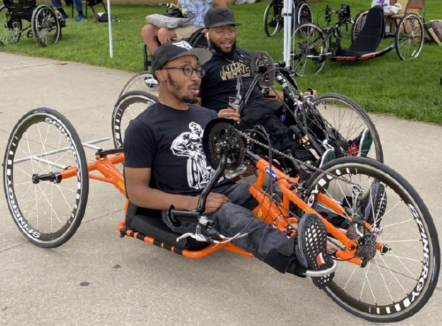Two men riding handcycle trikes