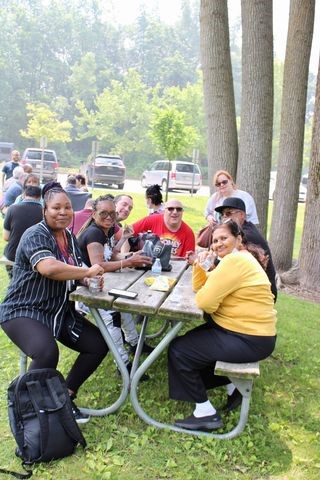 DNEM guests gather around a picnic table during an event